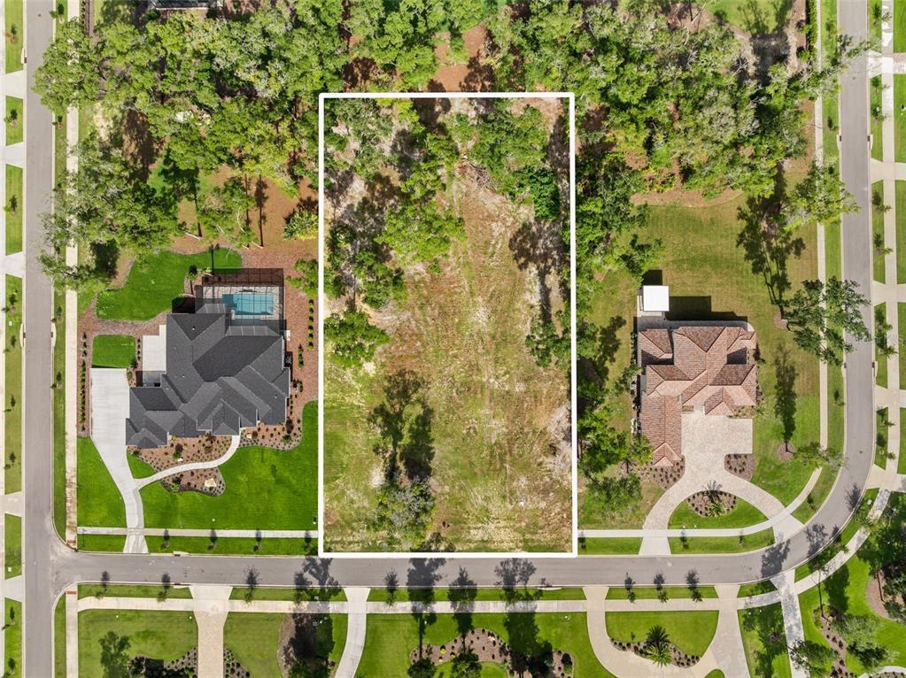 An aerial view shows a vacant rectangular lot situated between two existing residential homes — 3120 SW 108TH WAY, GAINESVILLE, FL