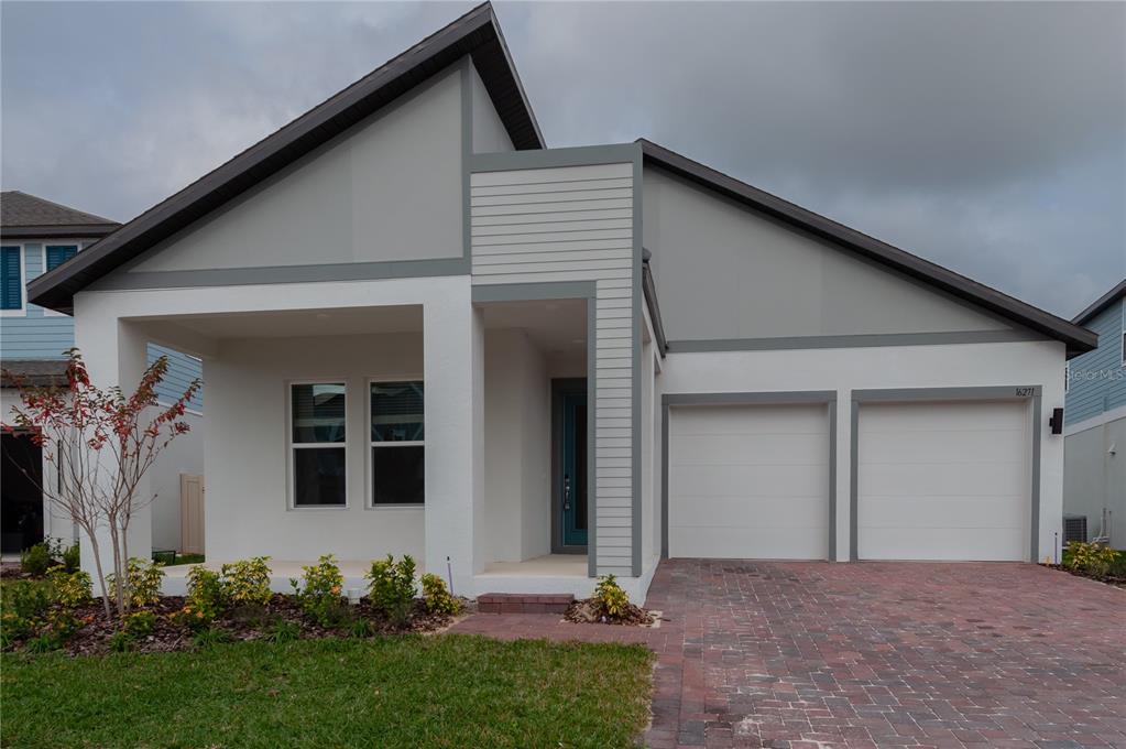 A modern single-story house with a white stucco facade, two garage doors, and a paved driveway — 16271 SILVER GROVE BLVD, WINTER GARDEN, FL