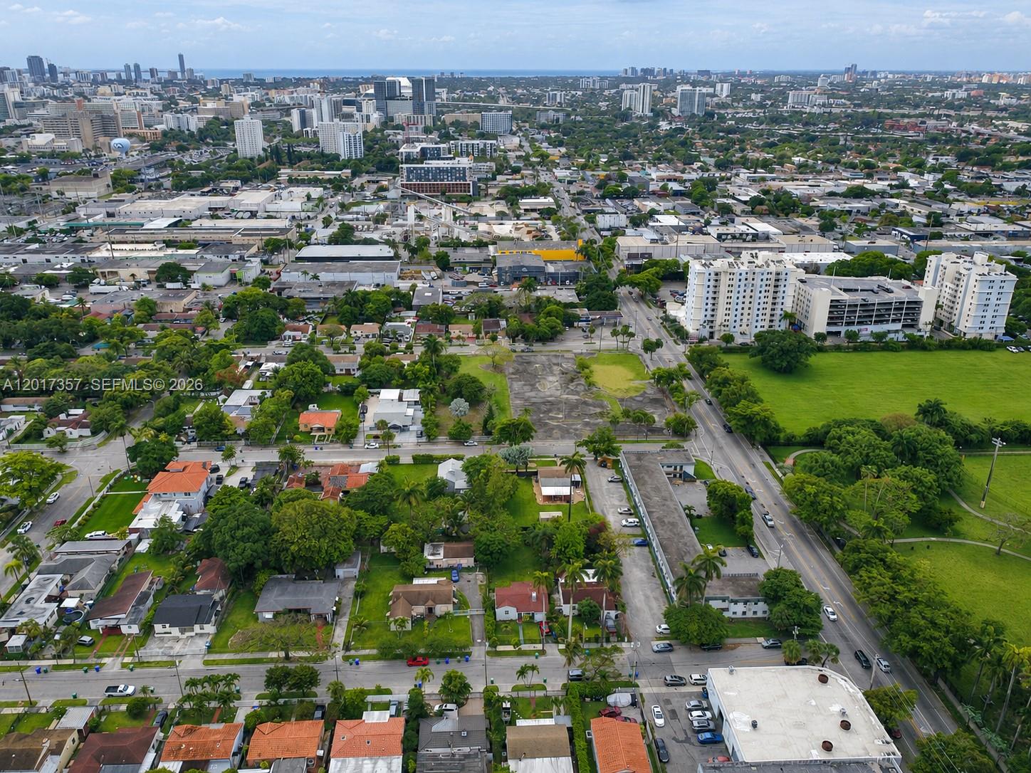 An aerial view shows a residential neighborhood with houses, apartment buildings, and a vacant lot — 1555 NW 26TH ST, Miami FL 33142, MIAMI, FL
