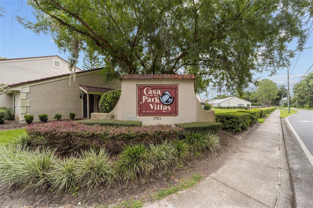 A sign for Casa Park Villas stands in front of a building and large tree — 1701 SE 24TH ROAD UNIT 102, OCALA, FL