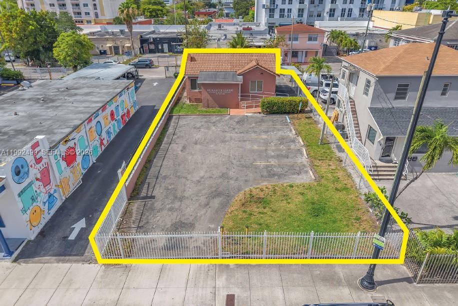 An aerial view shows a small building with a paved parking lot enclosed by fencing — 1437 SW 1st St, Miami FL 33135, MIAMI, FL