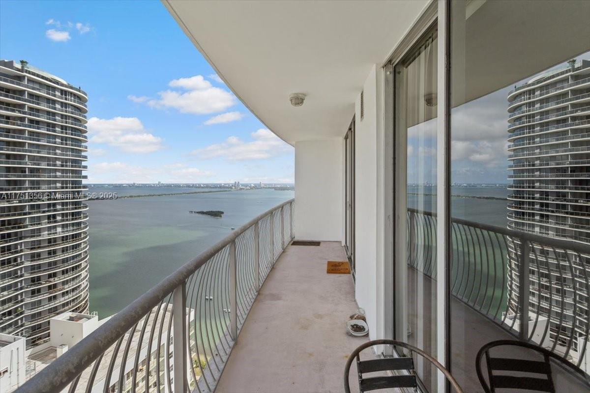 A balcony with a metal railing overlooks a large body of water and nearby high-rise buildings — 1750 N Bayshore Dr # 4809, Miami FL 33132, MIAMI, FL