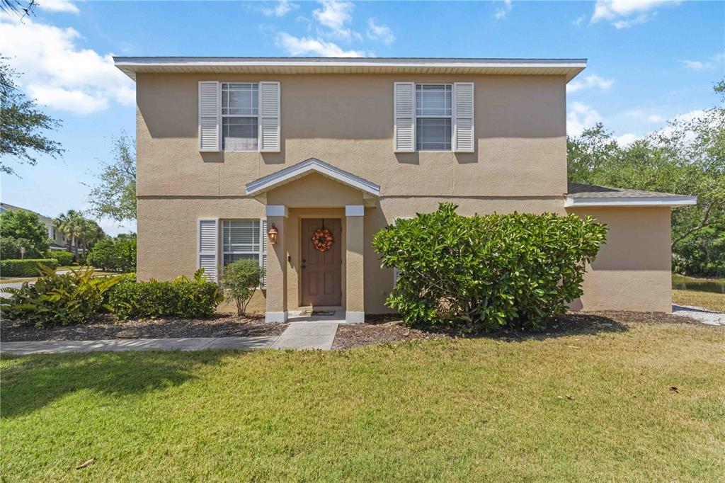 A two-story tan stucco house with a front porch and a small landscaped yard — 14969 AMBERJACK TERRACE UNIT 14969, BRADENTON, FL