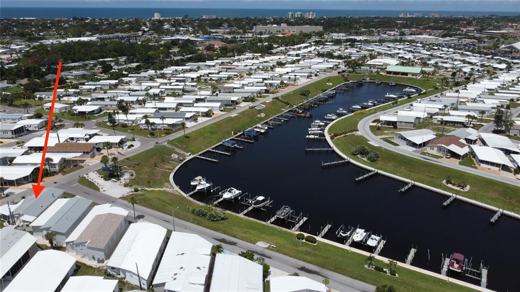An aerial view shows a mobile home community with a central canal and boat slips — 809 S WATERWAY, VENICE, FL