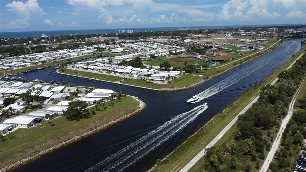 An aerial view shows a canal with two boats traveling past a residential community — 809 S WATERWAY, VENICE, FL