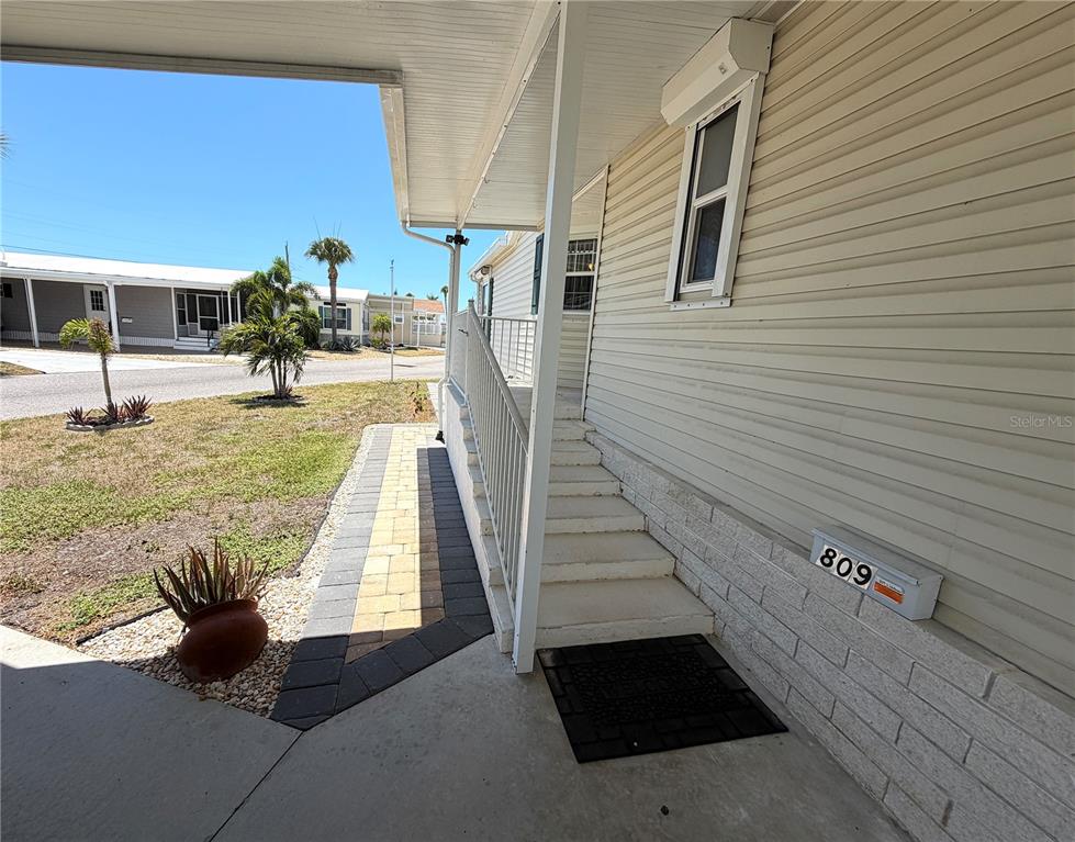 The exterior of a mobile home features a concrete walkway, stairs, and a mailbox — 809 S WATERWAY, VENICE, FL