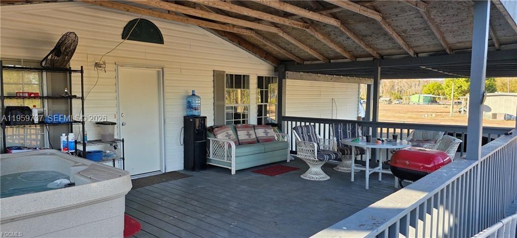 A white mobile home features a wooden deck and a landscaped garden bed — 1627 Sunset Tr, La Belle FL 33935, LA BELLE, FL