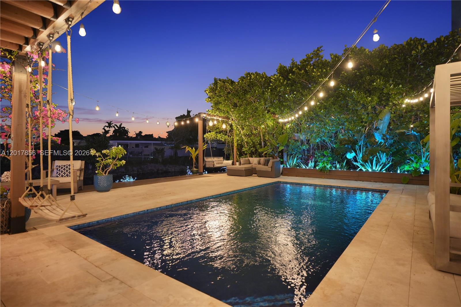 An outdoor swimming pool area features a patio, hanging swings, and string lights at dusk — 5241 SW 104th Ave, Miami FL 33165, MIAMI, FL