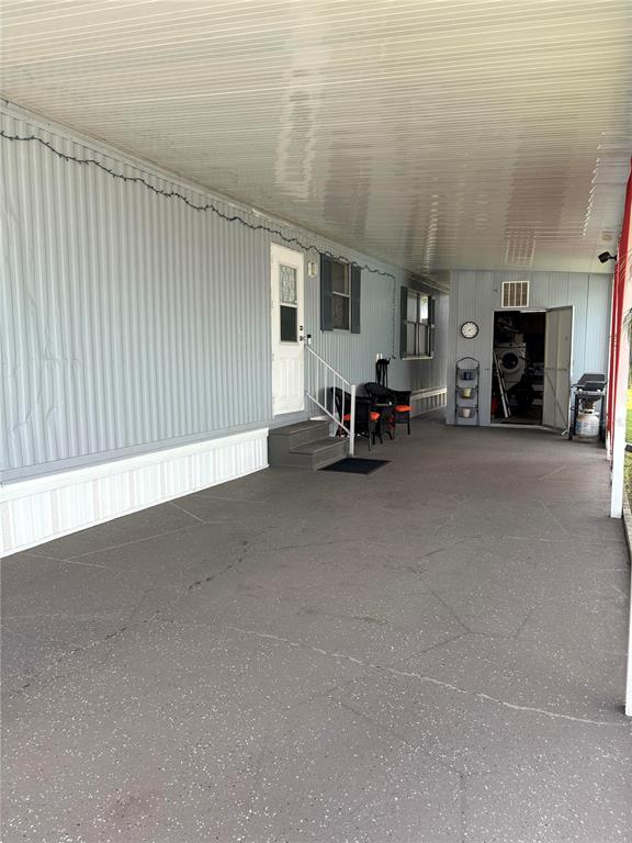 A covered carport area leads to the entrance of a mobile home with exterior siding — 2787 BREEZEWOOD DRIVE, NORTH FORT MYERS, FL
