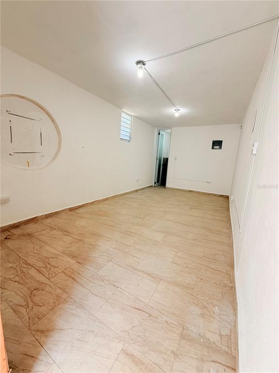 An empty room features beige tiled flooring, white walls, and exposed electrical conduit lighting — Calle 601 BLOQUE 224 COMERCIAL 3, CAROLINA, PR