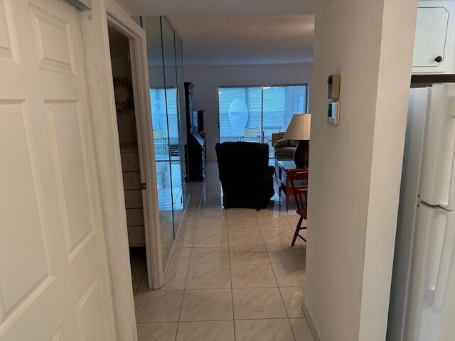A view from a doorway looking into a living room with tiled floors and mirrors — 7705 NW 5th Court # 103, Margate FL 33063, MARGATE, FL
