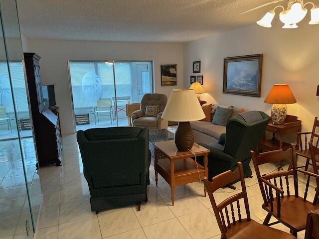 A living room features tile flooring, a sliding glass door, and several pieces of furniture — 7705 NW 5th Court # 103, Margate FL 33063, MARGATE, FL