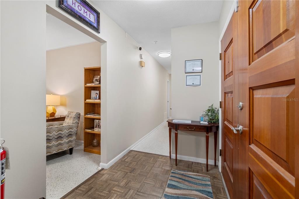 An entryway features a wooden door, a console table, and a view into a room — 207 W WHEELER ROAD, SEFFNER, FL