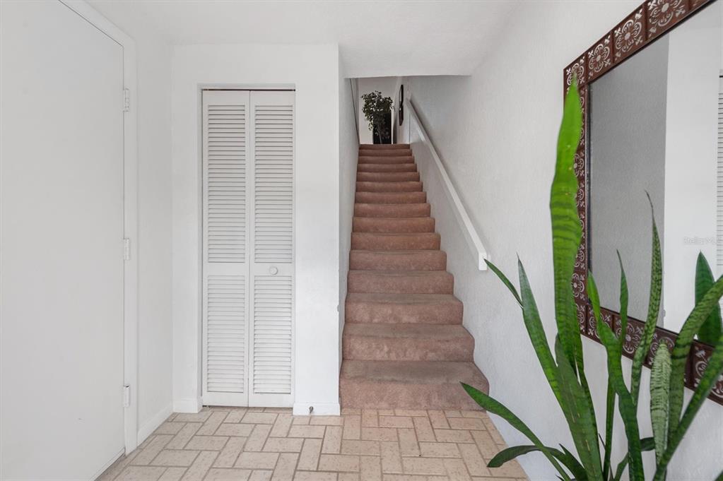 An entryway features a tiled floor, a louvered closet door, and carpeted stairs leading upward — 745 PINELLAS BAYWAY S UNIT 206, ST PETERSBURG, FL
