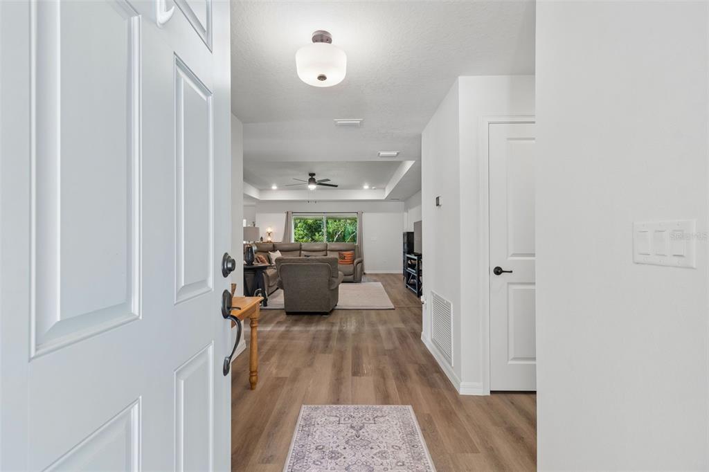 A view from an open front door into a hallway leading to a living room — 8948 CARRIE WAY, WEEKI WACHEE, FL