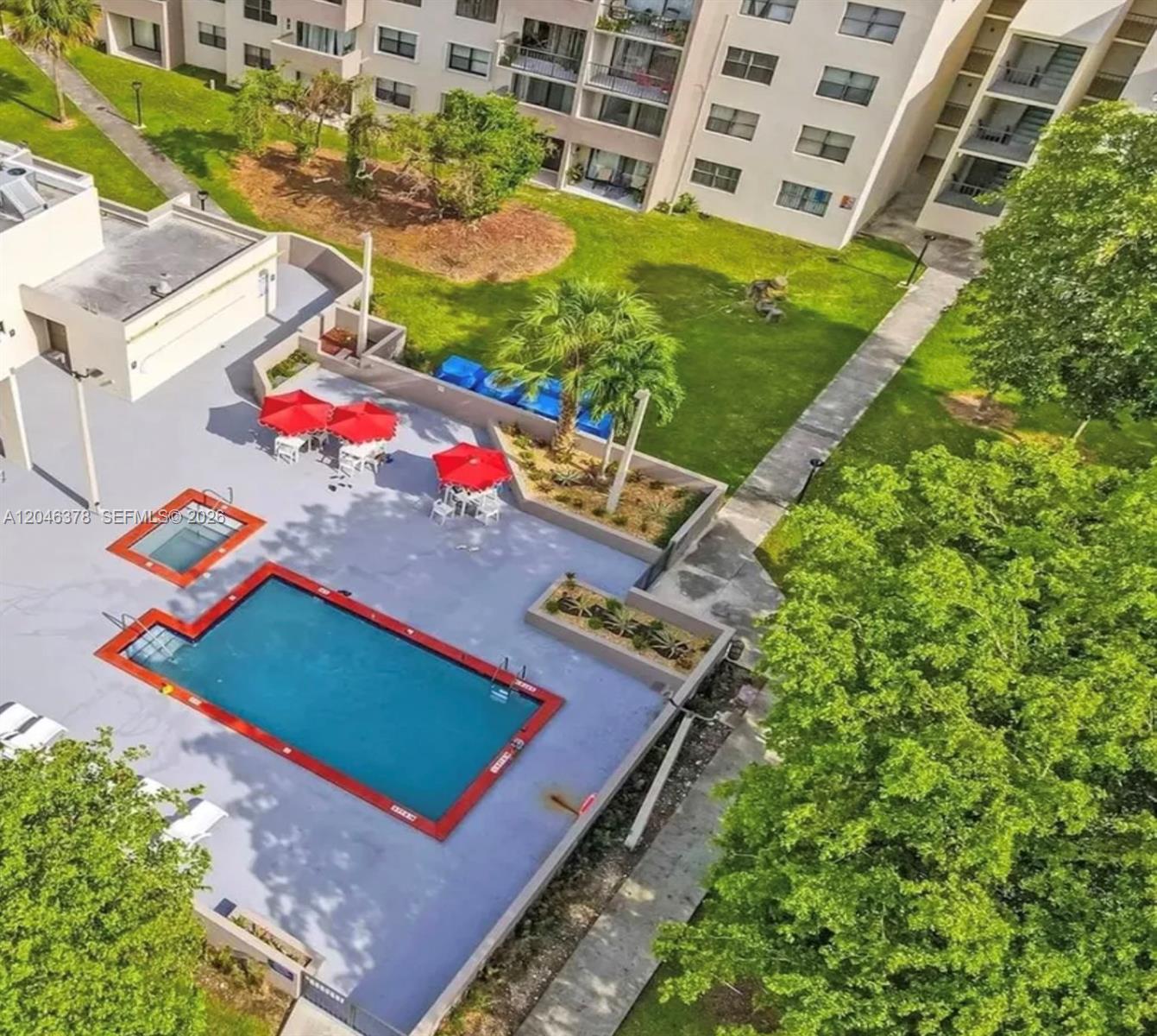 An aerial view shows a swimming pool, hot tub, and red umbrellas on a patio — 8004 SW 149th Ave # C205, Miami FL 33193, MIAMI, FL