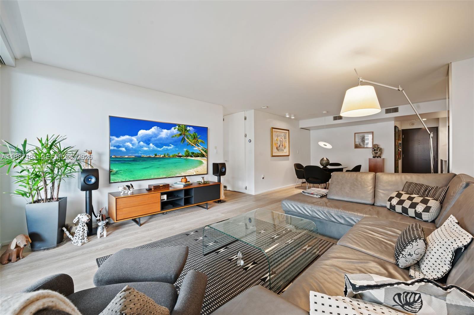 A modern living room features a large wall-mounted television, a leather sectional, and hardwood floors — 2901 S Bayshore Dr # 8E, Coconut Grove FL 33133, COCONUT GROVE, FL