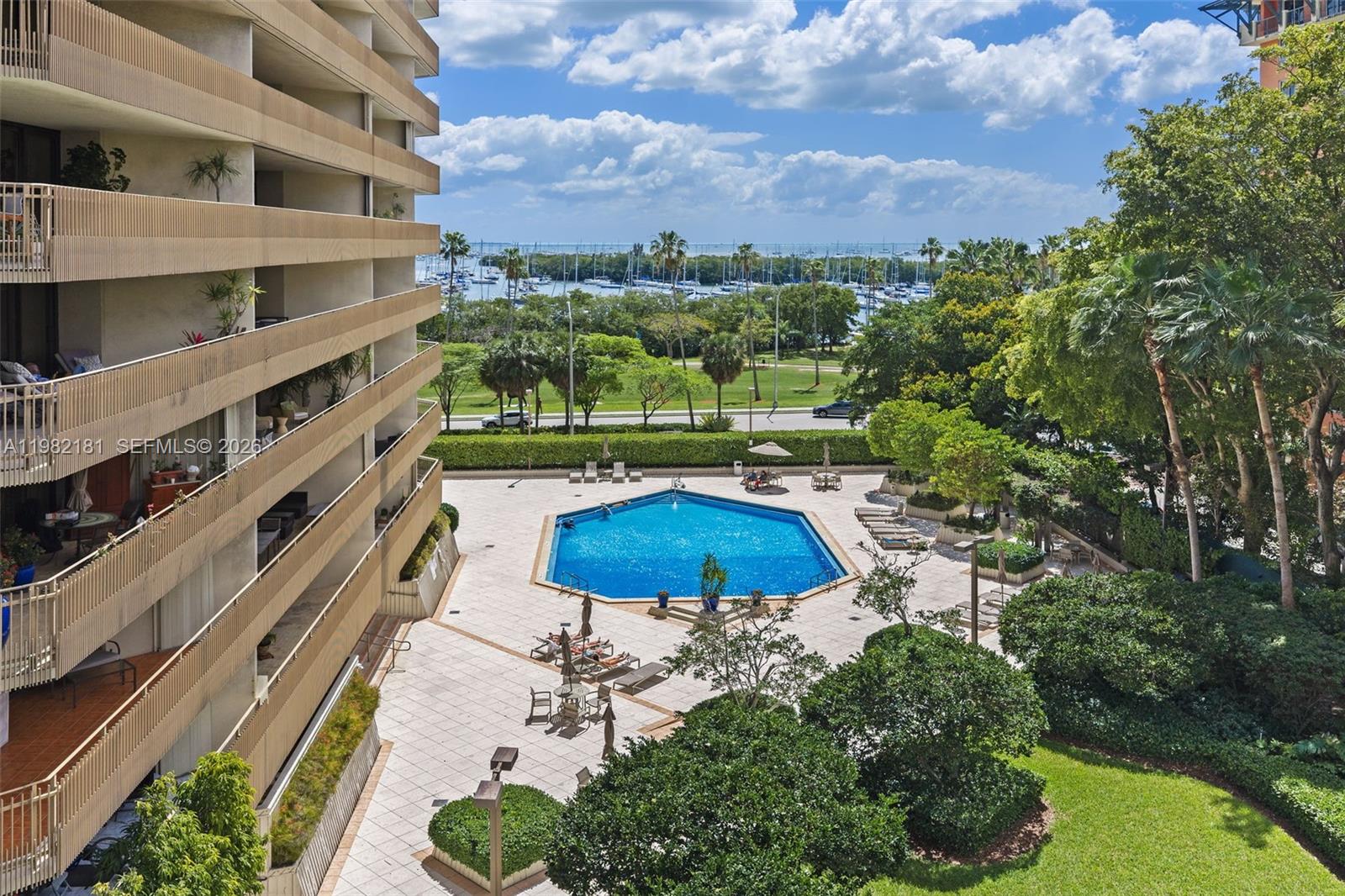 An elevated view shows a hexagonal swimming pool surrounded by a patio and lush landscaping — 2901 S Bayshore Dr # 8E, Coconut Grove FL 33133, COCONUT GROVE, FL