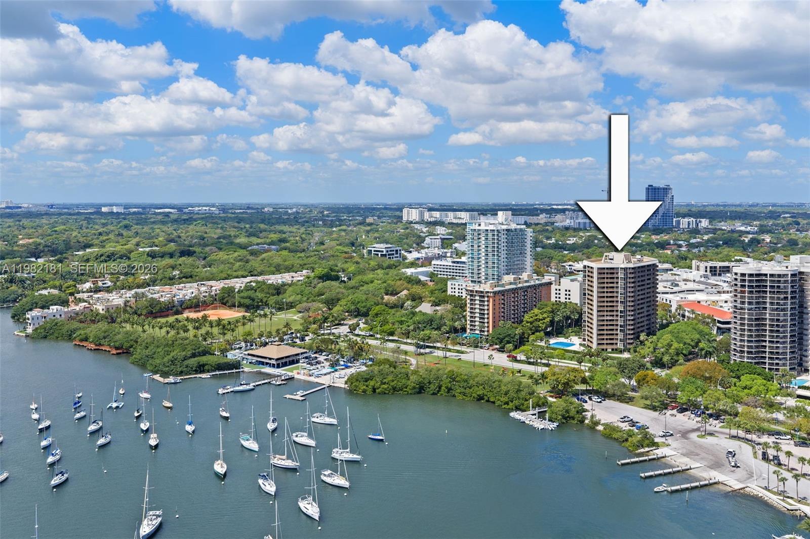 An aerial view shows a tall residential building marked by an arrow near a marina — 2901 S Bayshore Dr # 8E, Coconut Grove FL 33133, COCONUT GROVE, FL