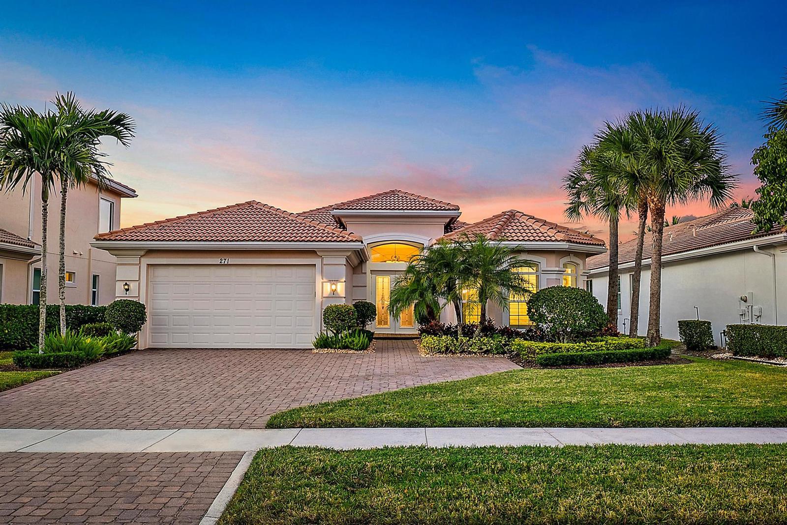 A single-story house with a tiled roof, brick driveway, and palm trees at dusk — 271 Carina Drive, Jupiter FL 33478, JUPITER, FL