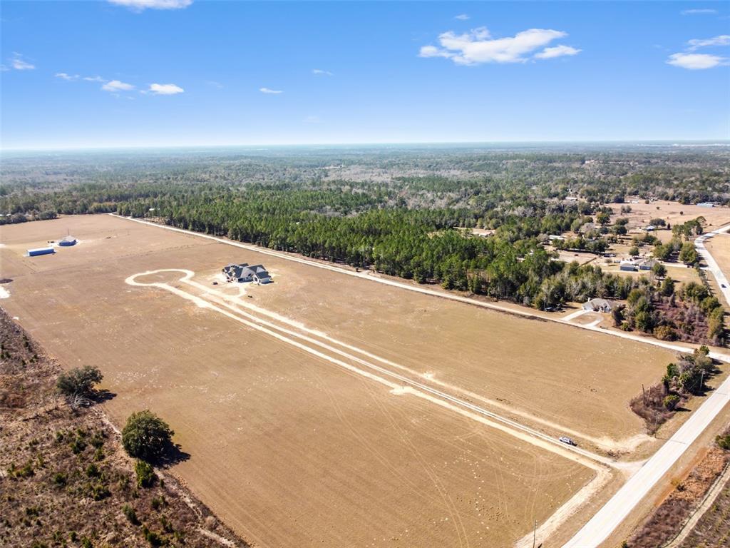 An aerial view shows a house situated on a large, cleared plot of land — 4302 ROYAL SKY (LOT 4) COURT, BROOKSVILLE, FL