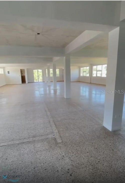 An expansive, open-concept interior space features white walls, structural support columns, and speckled concrete flooring — 57 PR2 KM57, BARCELONETA, PR