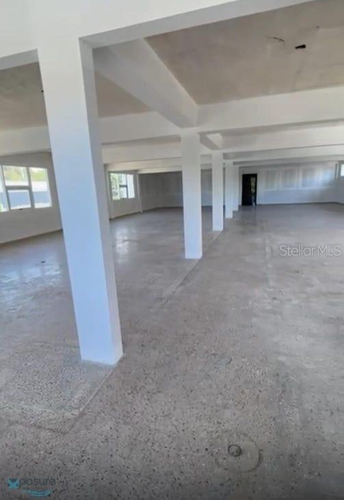 An open, unfinished commercial space features concrete floors, white support columns, and large windows — 57 PR2 KM57, BARCELONETA, PR