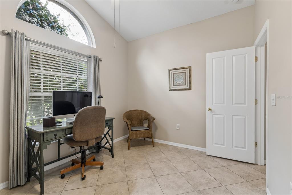 A home office features tile flooring, a desk with a computer, and a wicker chair — 30600 NICKERSON LOOP, WESLEY CHAPEL, FL