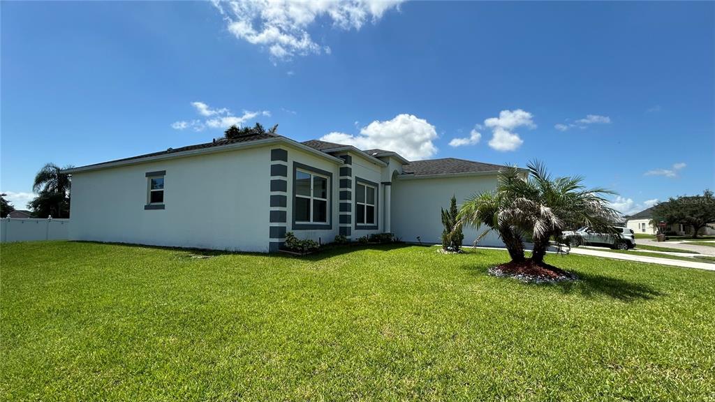 A kitchen features white cabinets, granite countertops, a stainless steel refrigerator, and a stone fireplace — 2713 WORTHAM LANE, KISSIMMEE, FL