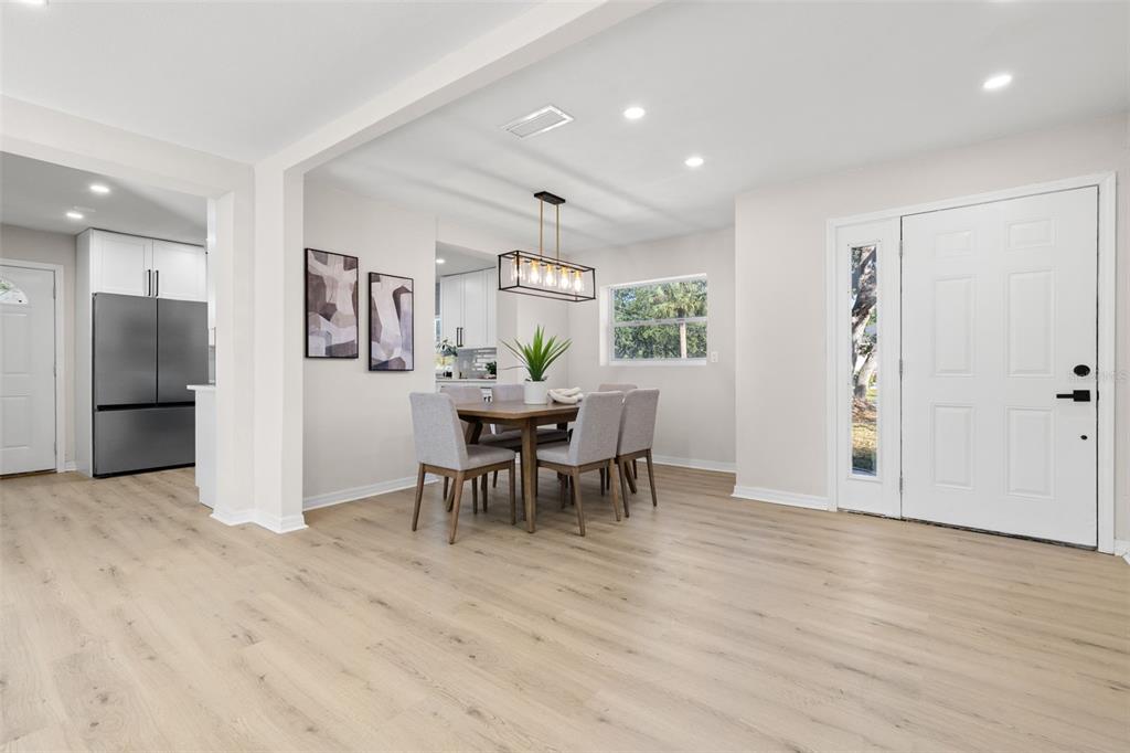 A dining area with a wooden table, grey chairs, and a rectangular pendant light fixture — 7301 S WEST SHORE BOULEVARD, TAMPA, FL