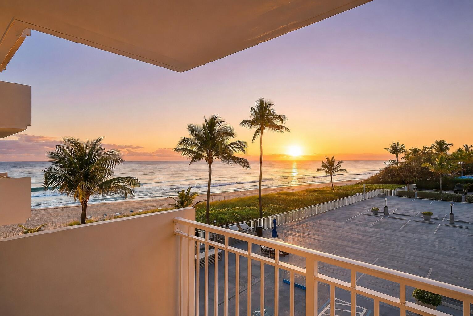 A balcony view overlooking a parking lot, palm trees, a sandy beach, and the ocean sunset — 3301 S Ocean Boulevard # 207, Highland Beach FL 33487, HIGHLAND BEACH, FL