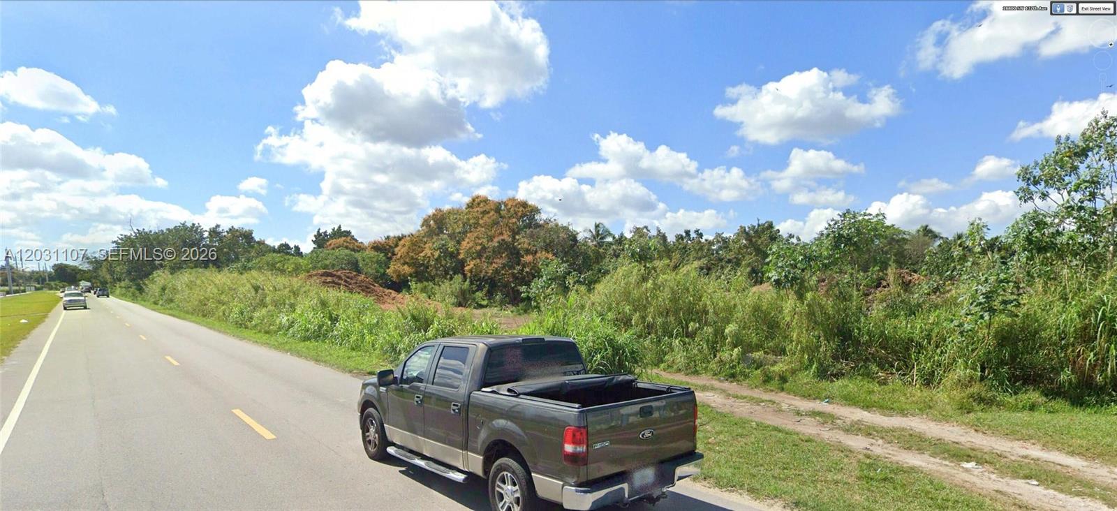A dark pickup truck is parked on the side of a road next to overgrown vegetation — 19000 SW 137th Ave, Miami FL 33177, MIAMI, FL