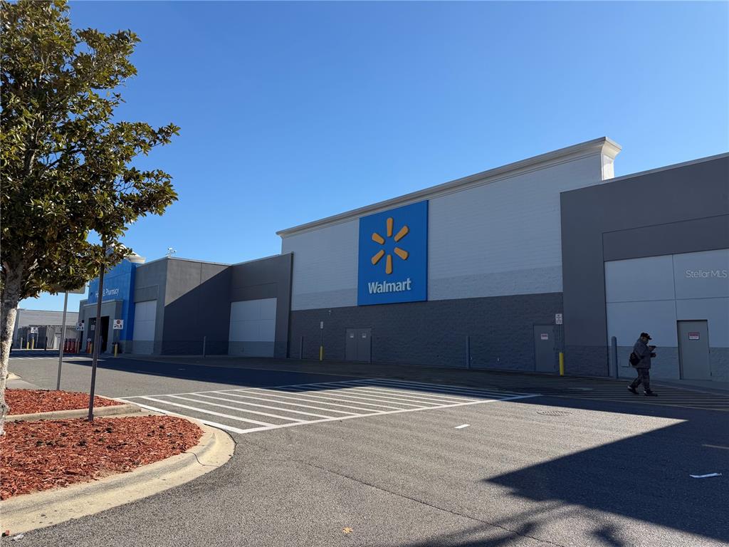 A view of a Walmart store exterior with a parking lot and a pedestrian — SW 135TH STREET ROAD LOT 12, OCALA, FL
