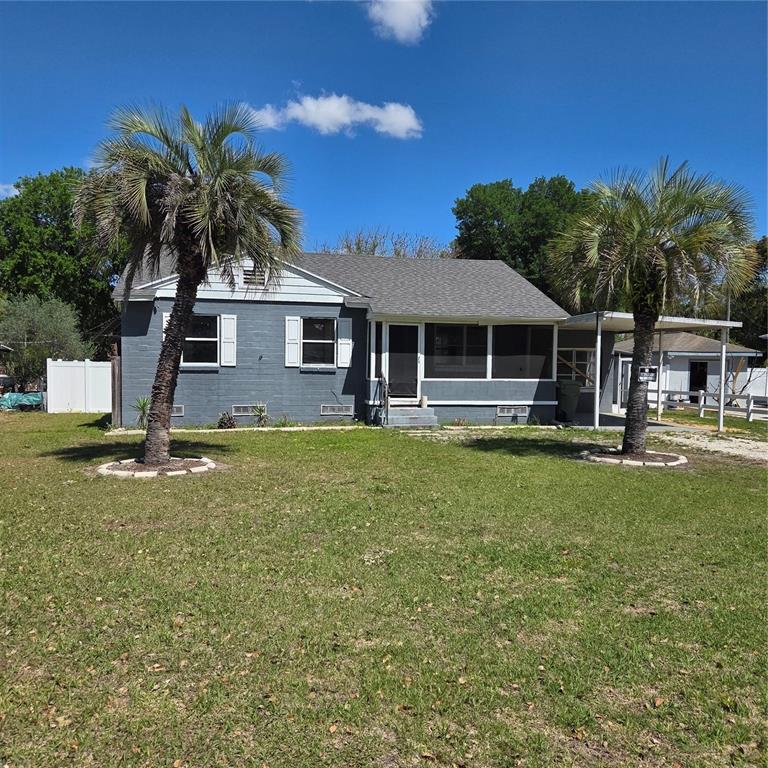 A gray, single-story house with a white fence and a small front yard — 2306 BUTLER STREET, LEESBURG, FL