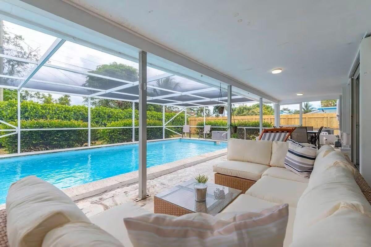 A covered patio features a swimming pool, outdoor seating, and a screened-in enclosure — 176 SE 27th Place, Boynton Beach FL 33435, BOYNTON BEACH, FL