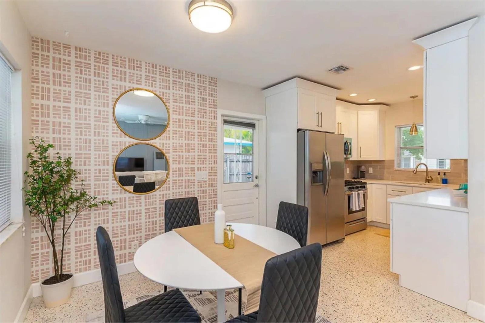 A dining area with patterned wallpaper, two round mirrors, and a white table with chairs — 176 SE 27th Place, Boynton Beach FL 33435, BOYNTON BEACH, FL