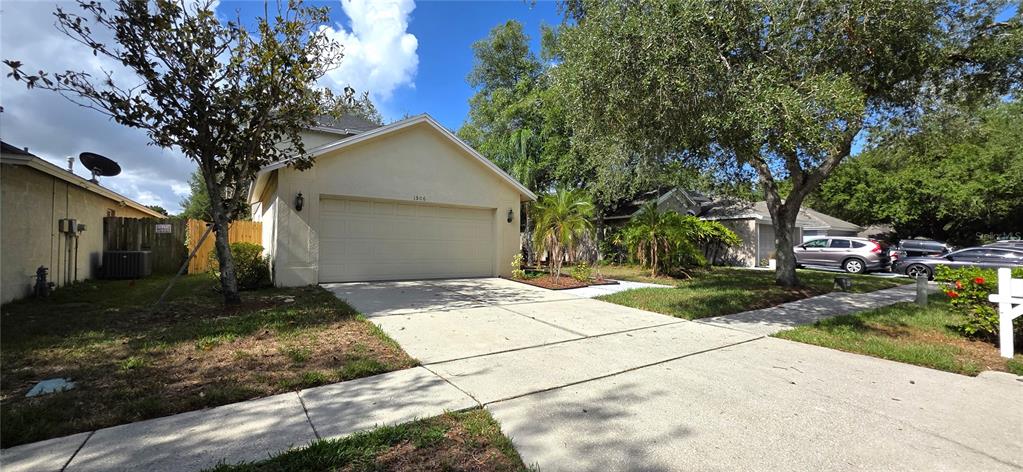 A beige single-story house with a two-car garage and a concrete driveway — 1506 SCOTCH PINE DRIVE, BRANDON, FL