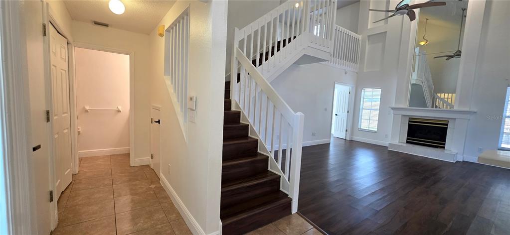 A foyer with tile flooring leads to a staircase and a living room with hardwood — 1506 SCOTCH PINE DRIVE, BRANDON, FL