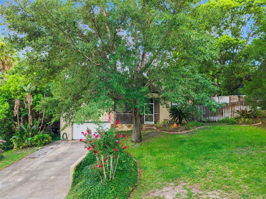 A single-story house with a concrete driveway, a large tree, and a front porch — 324 HICKORY COURT, APOPKA, FL