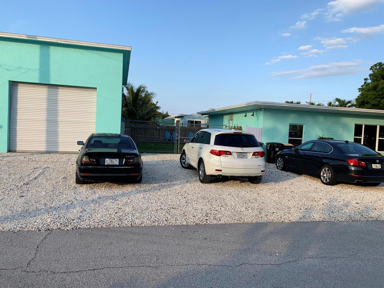 Three cars are parked on a gravel lot in front of two turquoise buildings — 142 Eldorado Street, Fort Pierce FL 34949, FORT PIERCE, FL