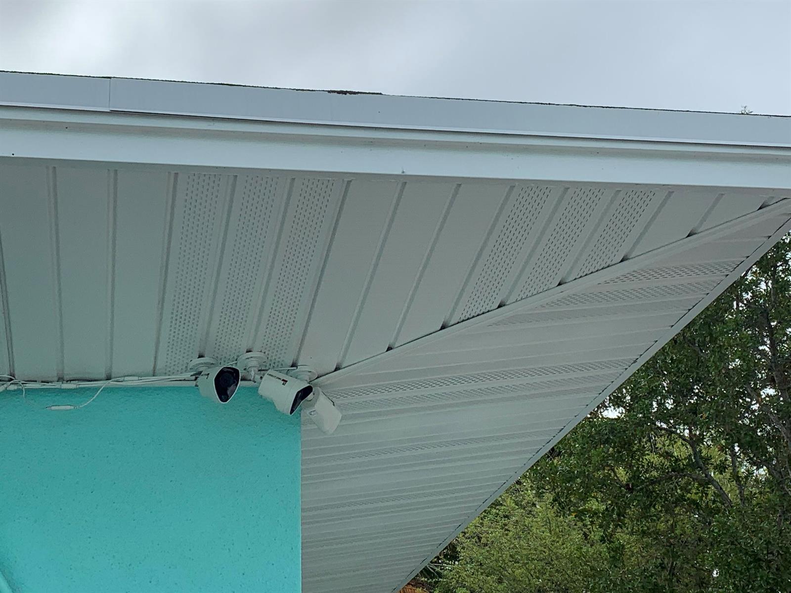 Two security cameras are mounted on the exterior soffit of a turquoise house — 142 Eldorado Street, Fort Pierce FL 34949, FORT PIERCE, FL