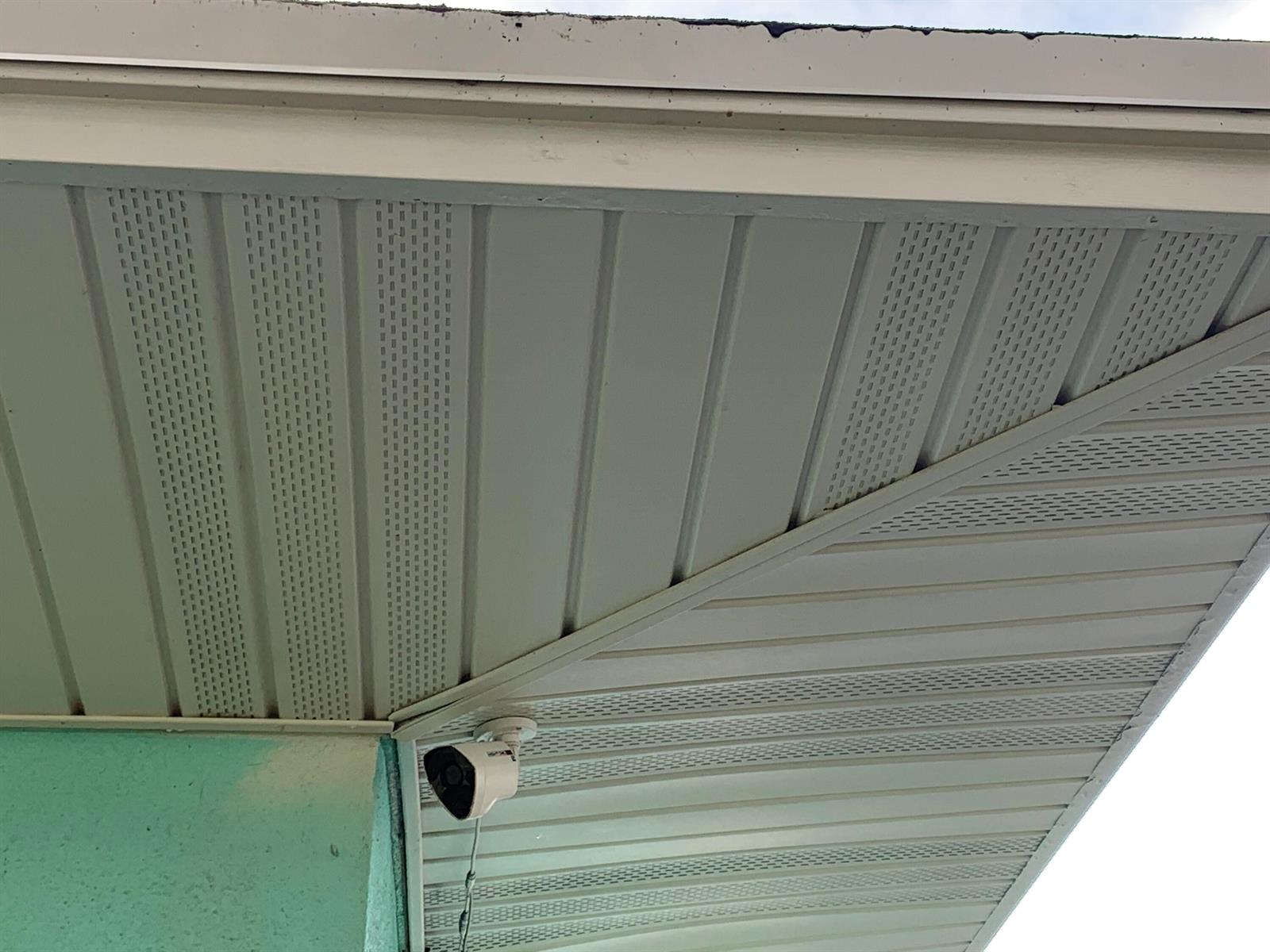 A security camera is mounted to the vinyl soffit under the eaves of a house — 142 Eldorado Street, Fort Pierce FL 34949, FORT PIERCE, FL