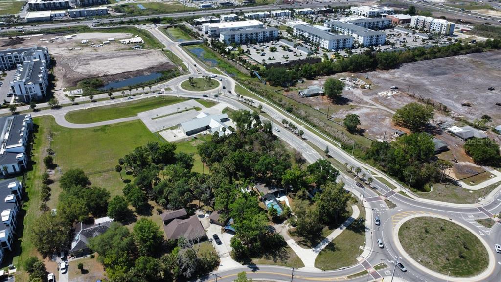 An aerial view shows a residential property surrounded by trees, roads, and nearby apartment complexes — 6480 RICHARDSON ROAD, SARASOTA, FL