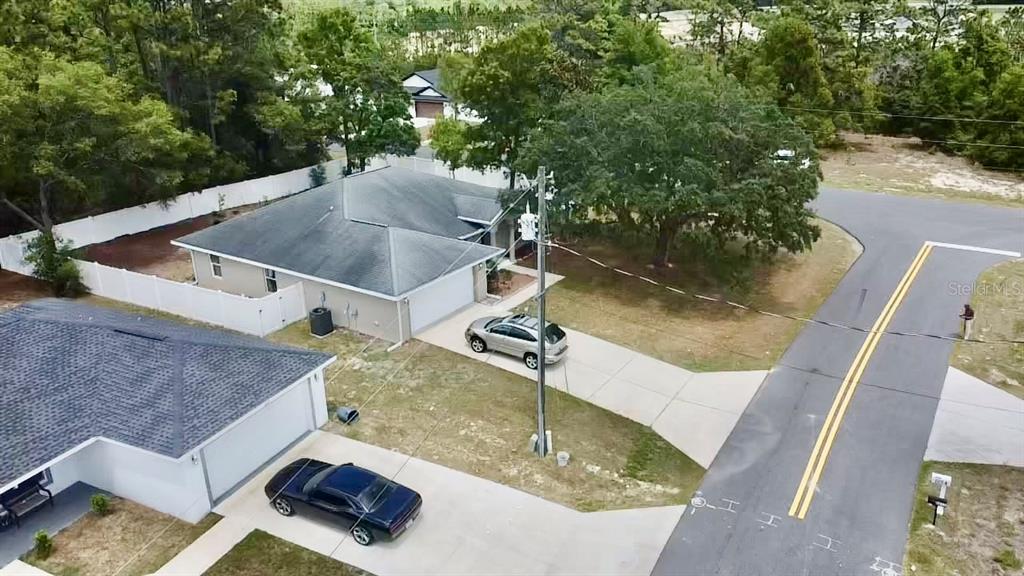 An aerial view shows two suburban houses with driveways and cars next to a road — 6021 SW 131ST LANE UNIT 10, OCALA, FL