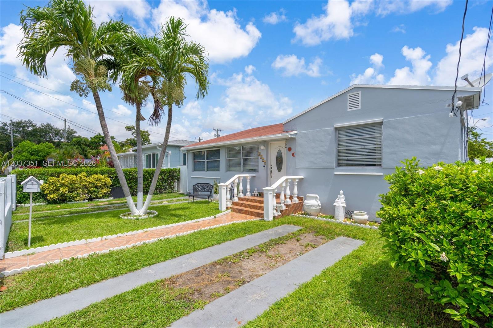 A light gray single-story house features a tiled walkway, palm trees, and a front lawn — 2355 SW 1st St, Miami FL 33135, MIAMI, FL