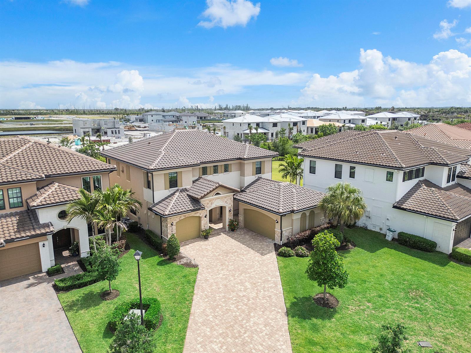 An aerial view shows three suburban houses with tiled roofs and paved driveways — 12745 Bayside Court, Parkland FL 33076, PARKLAND, FL
