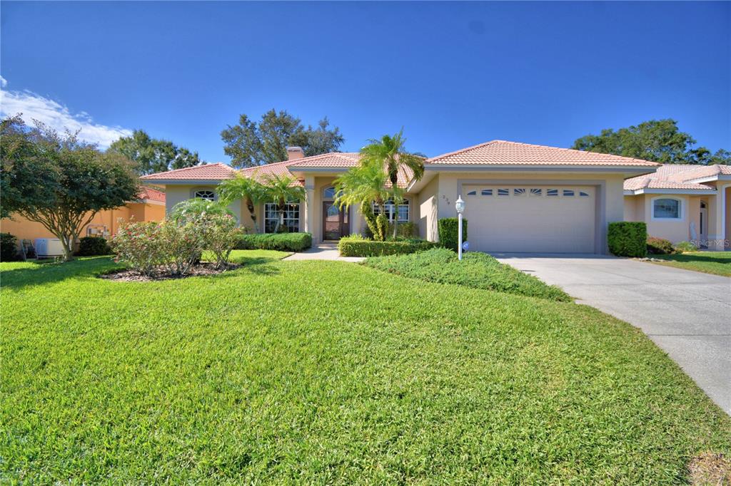 A single-story house with a tile roof, two-car garage, and a manicured front lawn — 239 GOLF AIRE BOULEVARD, WINTER HAVEN, FL