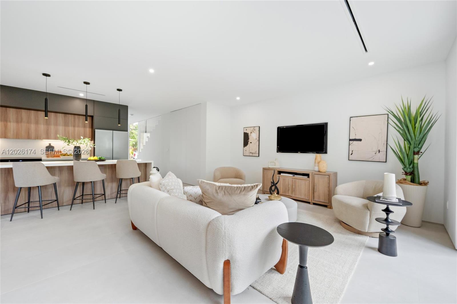 A modern open-concept living room features a kitchen island, neutral furniture, and light flooring — 2980 SW 2nd St, Miami FL 33135, MIAMI, FL