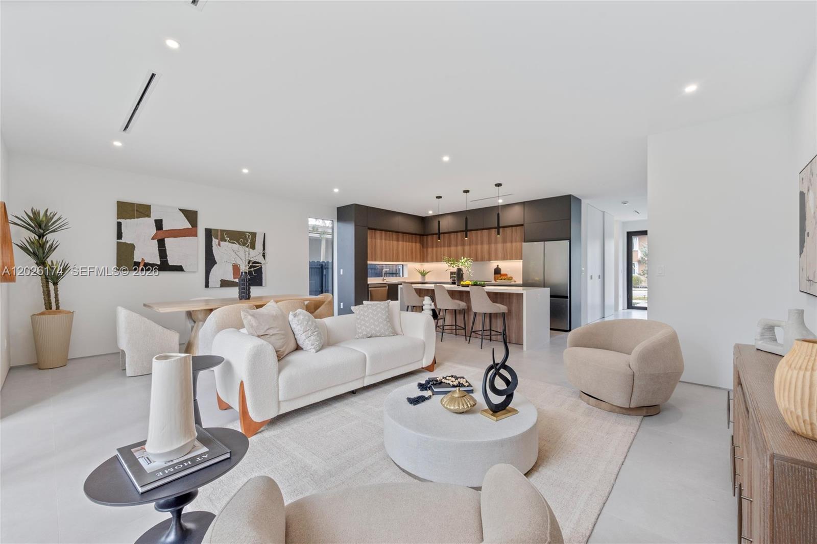 An open-concept living and dining area features a modern kitchen with wood cabinetry and island — 2980 SW 2nd St, Miami FL 33135, MIAMI, FL