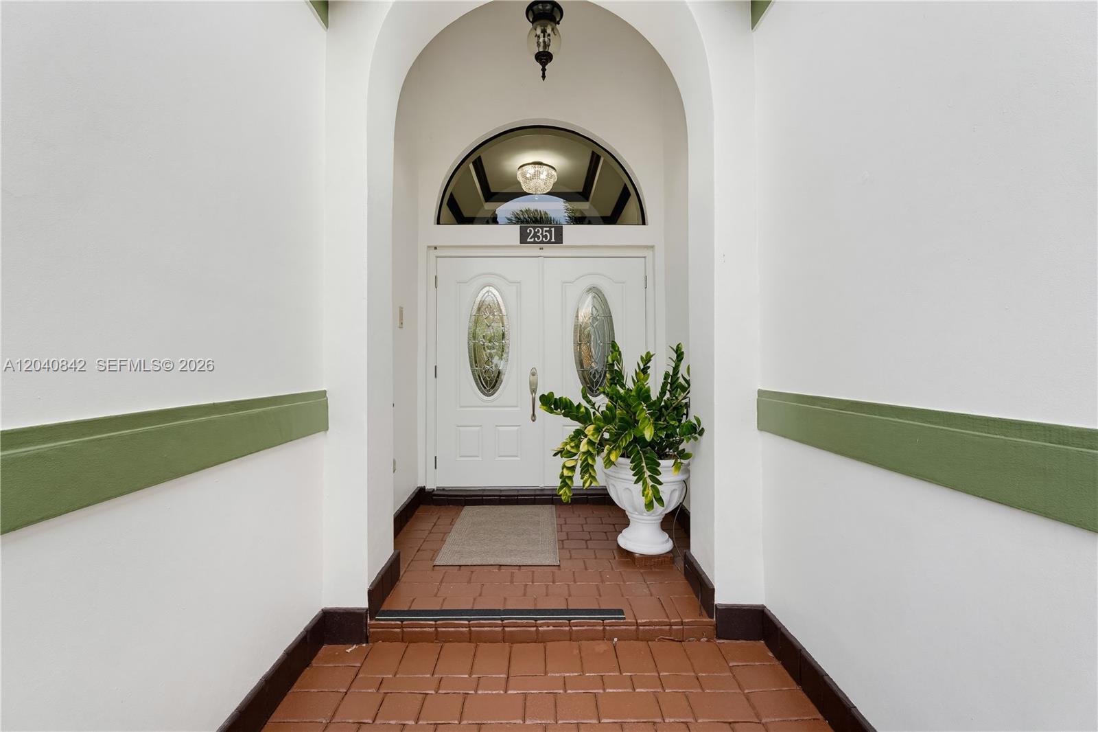 An arched entryway features white double doors with glass inserts and a brick floor — 2351 SW 145th Ave, Miami FL 33175, MIAMI, FL